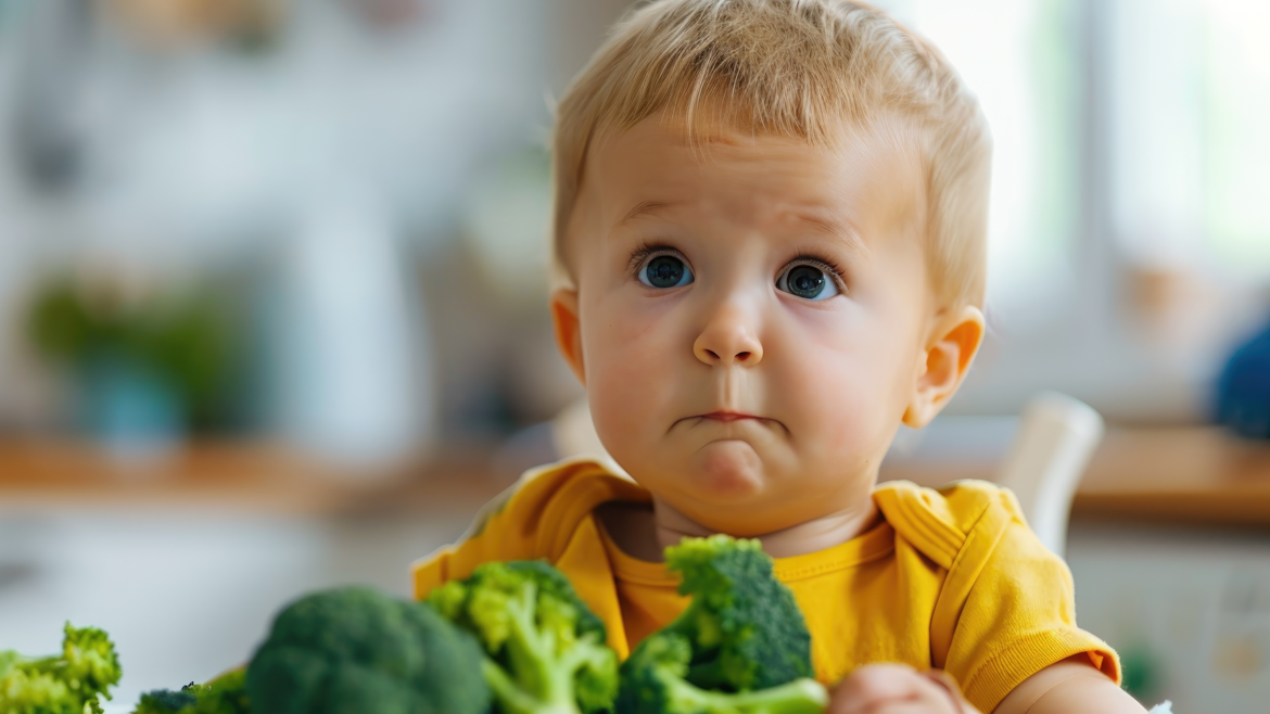 Kleines Kind verzieht Gesicht beim Brokkoli essen