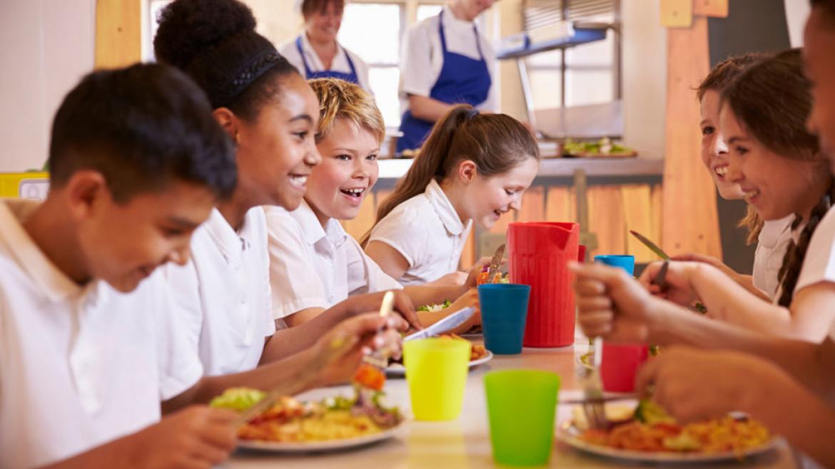 Kinder in Schulmensa am Tisch