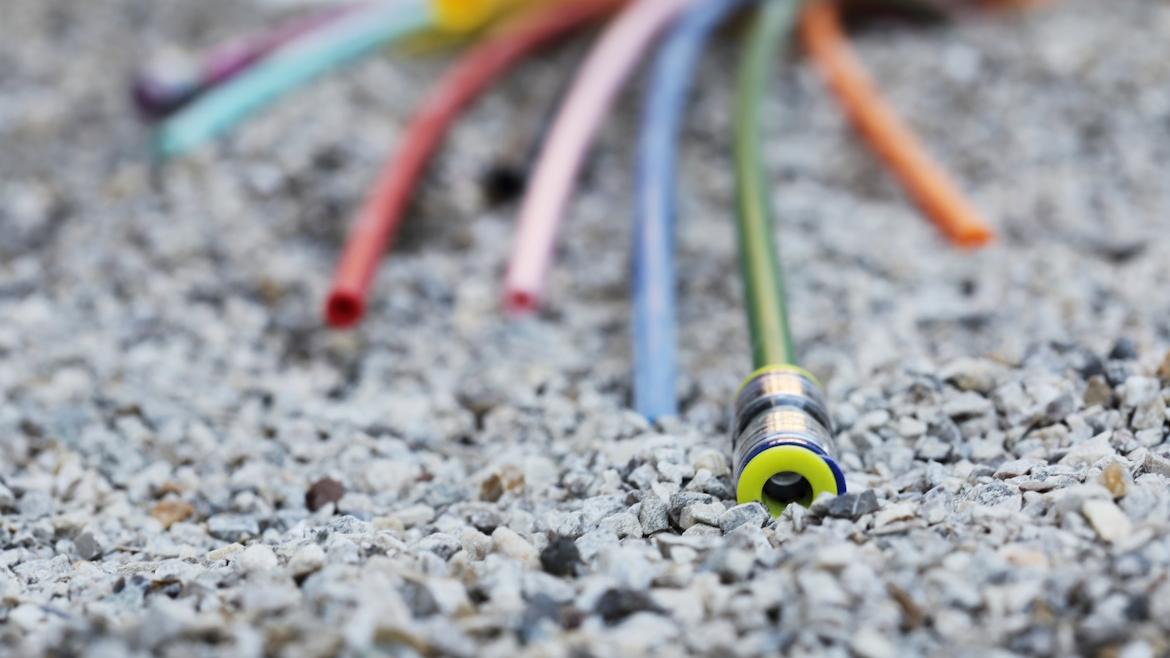 Verschieden bunte Kabel auf Schotter, Glasfaser