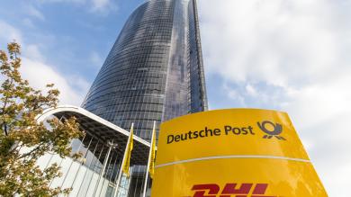 Postfiliale DHL Filiale Schild und riesen Postfiliale als Hochhaus im Hintergrund