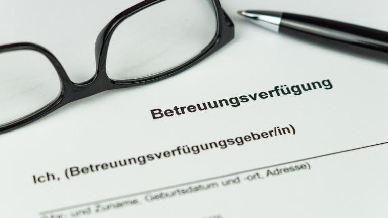 Brille und Stift liegen auf Dokument Betreuungsverfügung