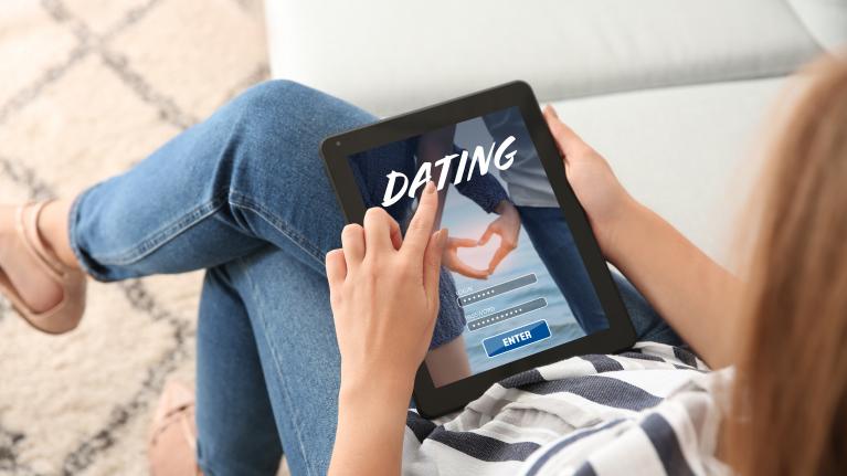 Frau mit Tablet auf Schoß auf Sofa zu Artikel: Partnervermittlung - Bessere Chancen beim Widerruf