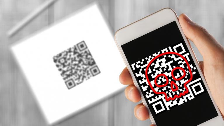 Hintergrund: Tablet mit QR-Code, vorne von Smartphone gescannter QR-Code mit rotem Totenkopf