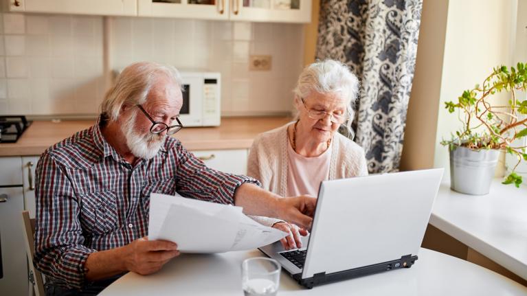 Älteres Ehepaar in Küche am Laptop zu Artikel: Wenn der Kontowechsel schiefgeht