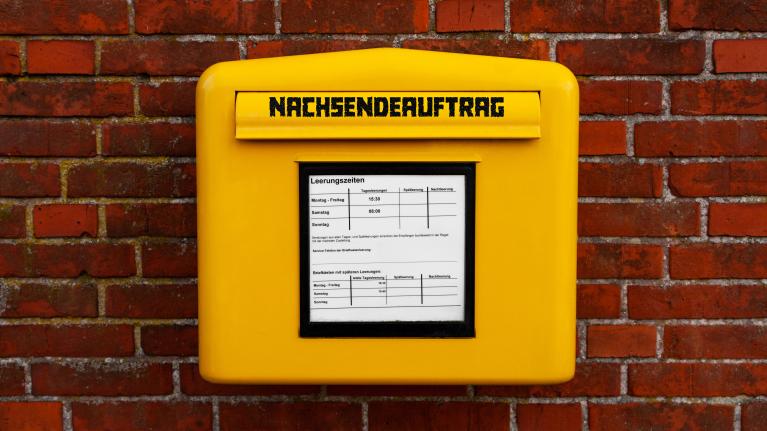 Nachsendeauftrag auf gelbem Briefkasten