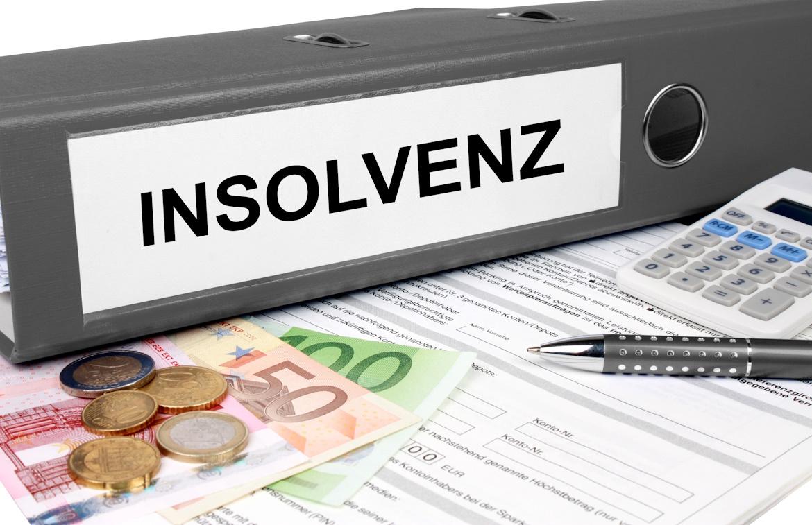 Insolvenzordner grau mit Taschenrechner, Stift und Geld