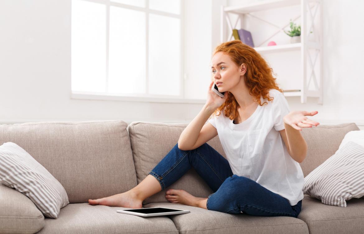 Frau auf Sofa telefoniert