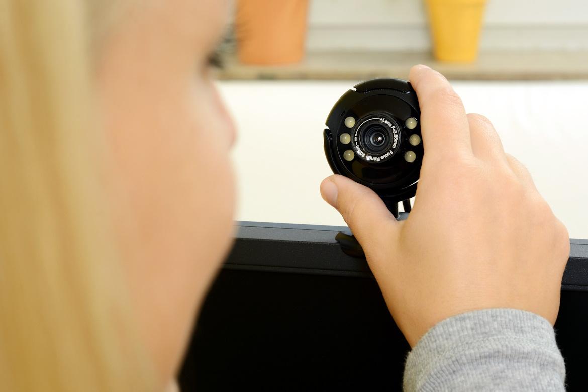 Frau mit Webcam auf Computermonitor