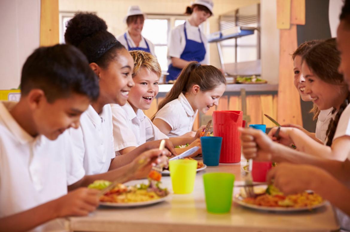 Kinder in Schulmensa am Tisch