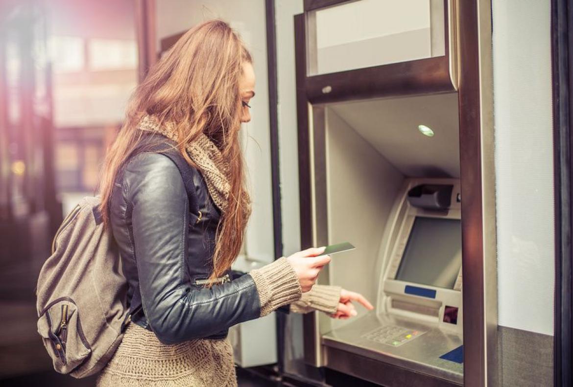 Junge Frau am geldautomat Finanzen