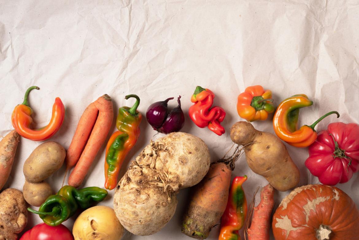 Unperfekte Möhren, Kartoffeln, Tomaten, Paprika, Sellerie auf hellem Tuch