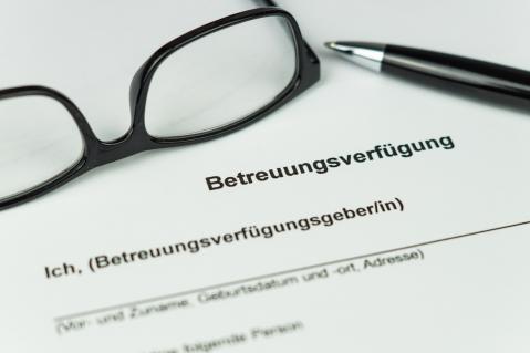 Brille und Stift liegen auf Dokument Betreuungsverfügung