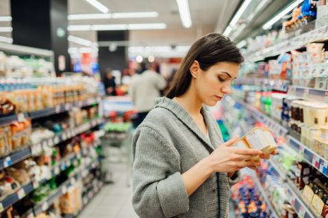 Frau im Supermarkt vor Regal